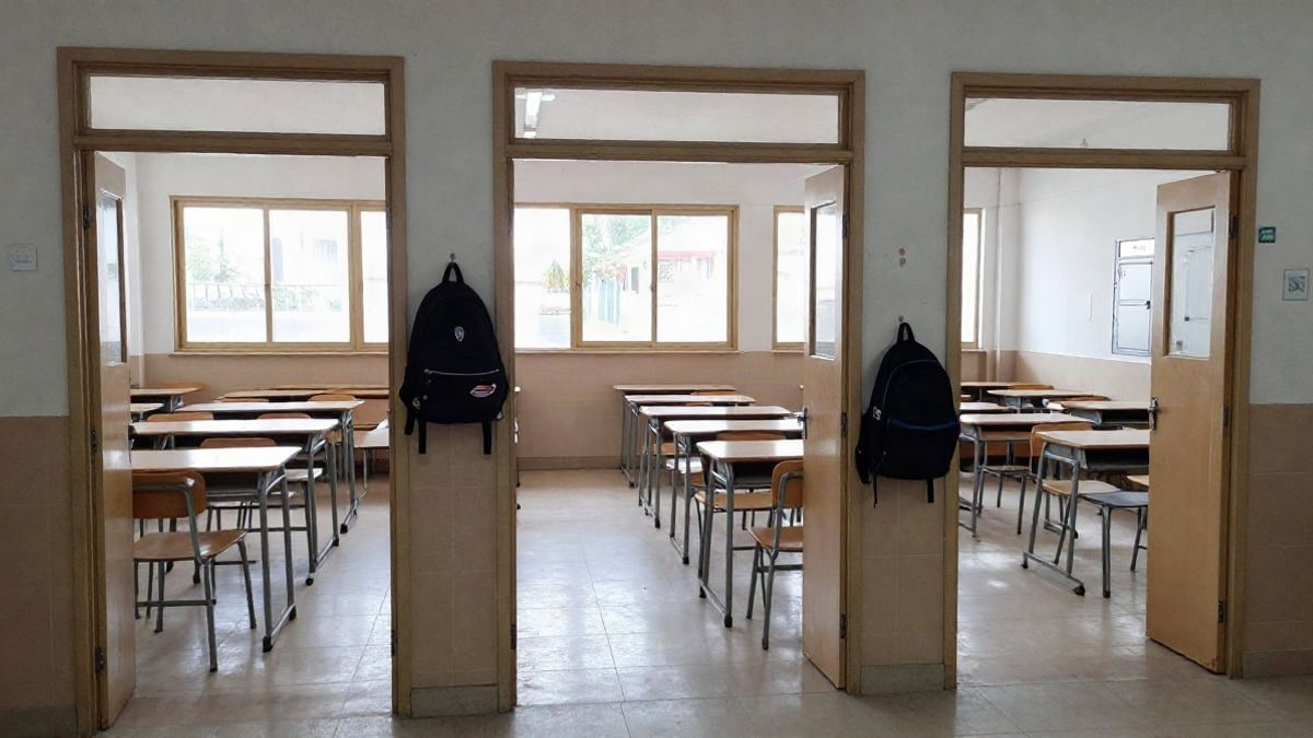 Imagen ilustrativa: pasillo de una escuela española con aulas vacías y luz natural